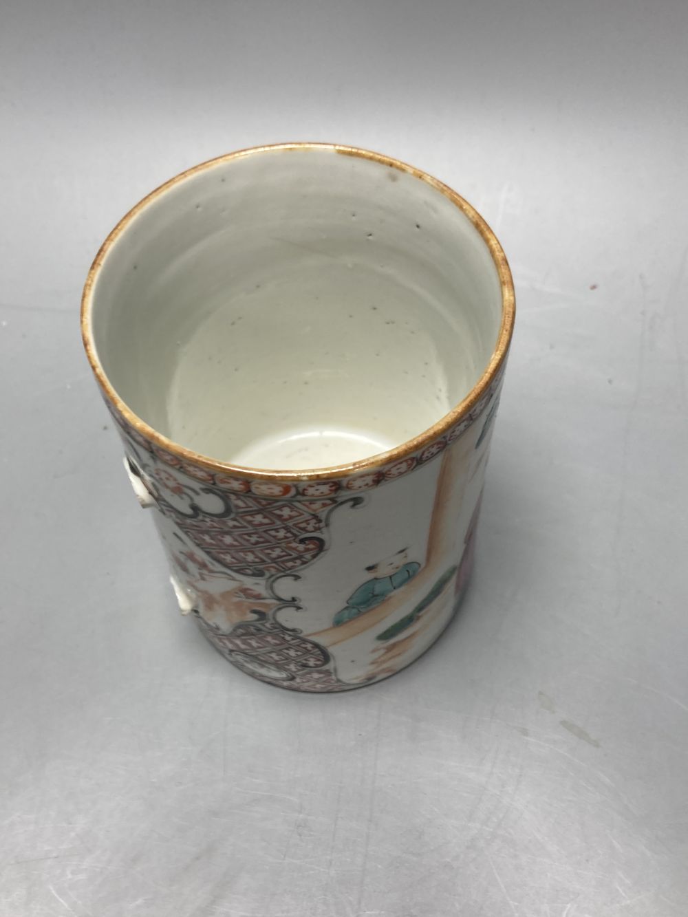 An 18th century Chinese famille rose plate together with a Chinese blue and white plate and a famille rose mug lacking handle, largest